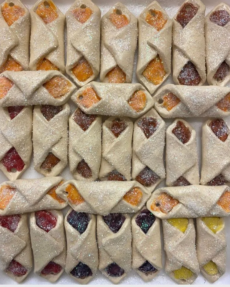 Rows of glittered ceramic pastry ornaments in cream, orange and berry colors