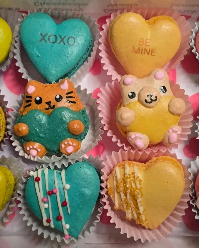 A box of colorful heart and animal-shaped miniature macarons