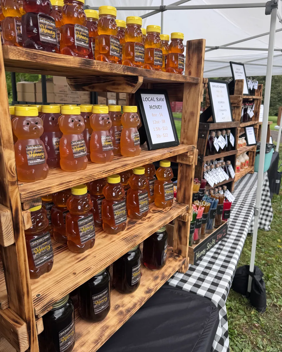 Shelves of honey bottles at a Smith Brothers Sweets outdoor market display
