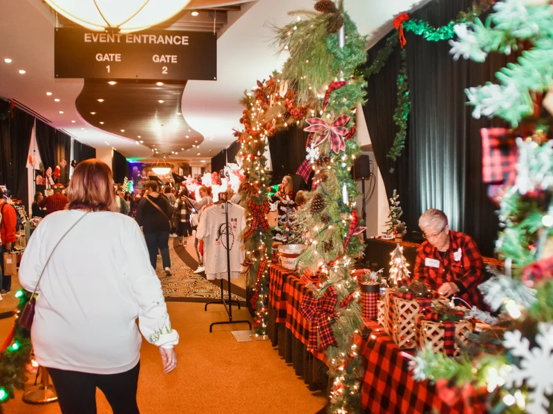 A shopper walks in through the garland-framed event entrance at the 2025 Ohio Made Holiday Market.