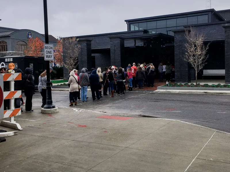 People wait in a line that runs from the road to a dark brick and glass entrance at the first Ohio Made Holiday Market in 2016.