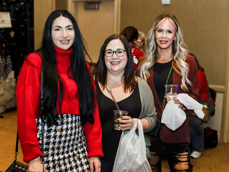 Three guests smile near a hall exit at the 2023 Ohio Made Holiday Market.
