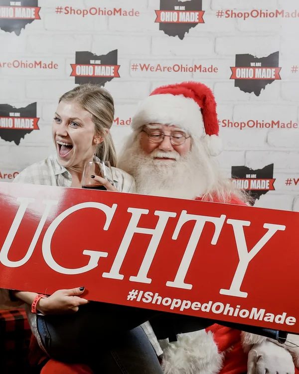 Santa poses with attendees in front of the branded backdrop.