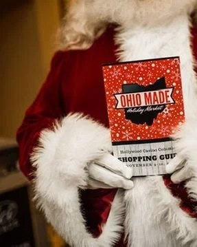 Santa's gloved hands hold a printed Shopping Guide.