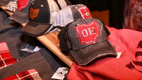 Ohio-themed caps on a maker booth table.