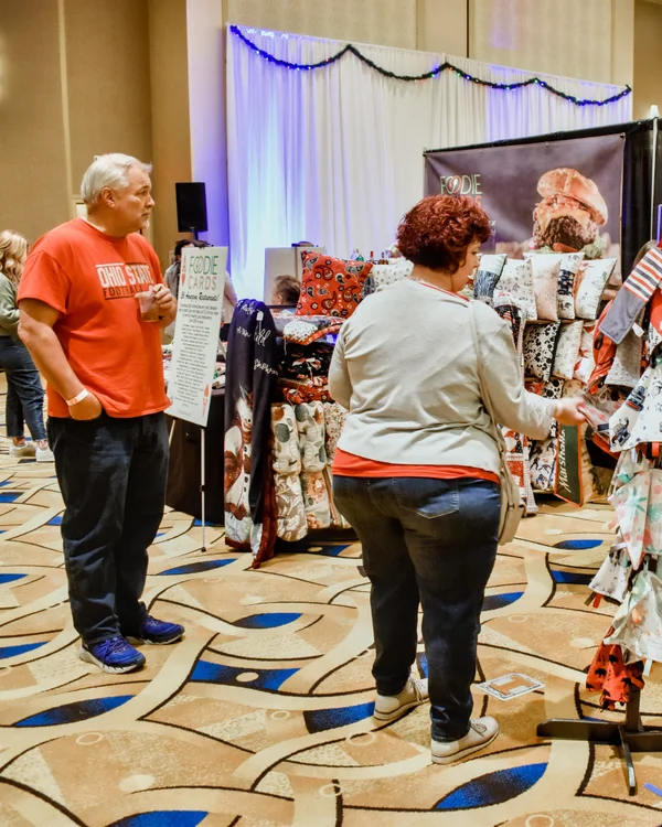 Shoppers wander past racks of handmade pillows and clothing at the 2023 Ohio Made Holiday Market.