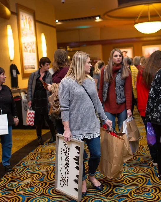 A shopper carries a wooden sign and shopping bags through the 2018 Ohio Made Holiday Market.
