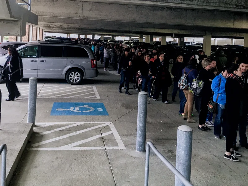 A long line of people waits beside parked cars under a covered parking structure at the first Ohio Made Holiday Market in 2016.